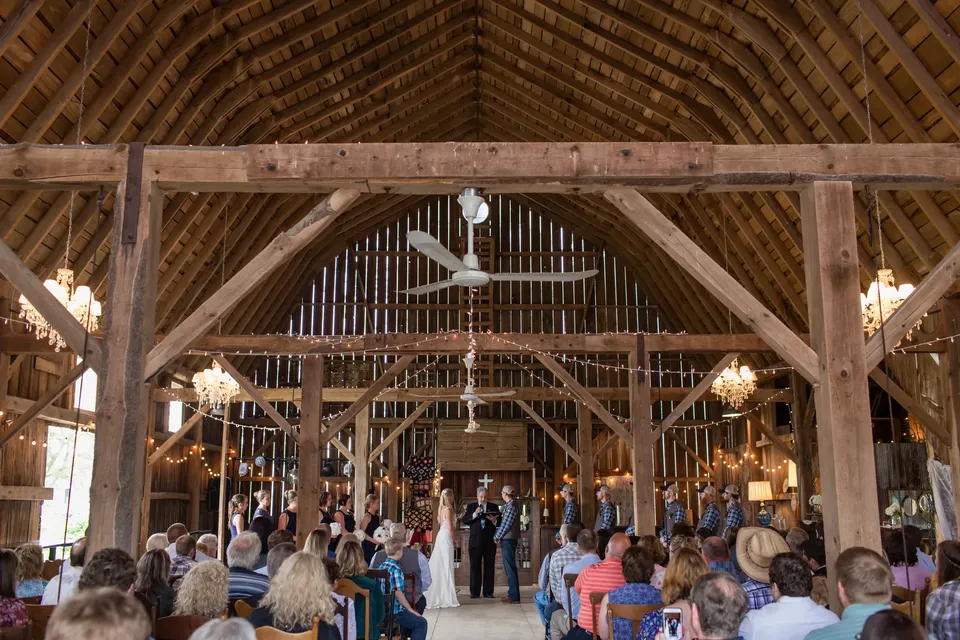 Guests seated for a ceremony inside the timber framed barn