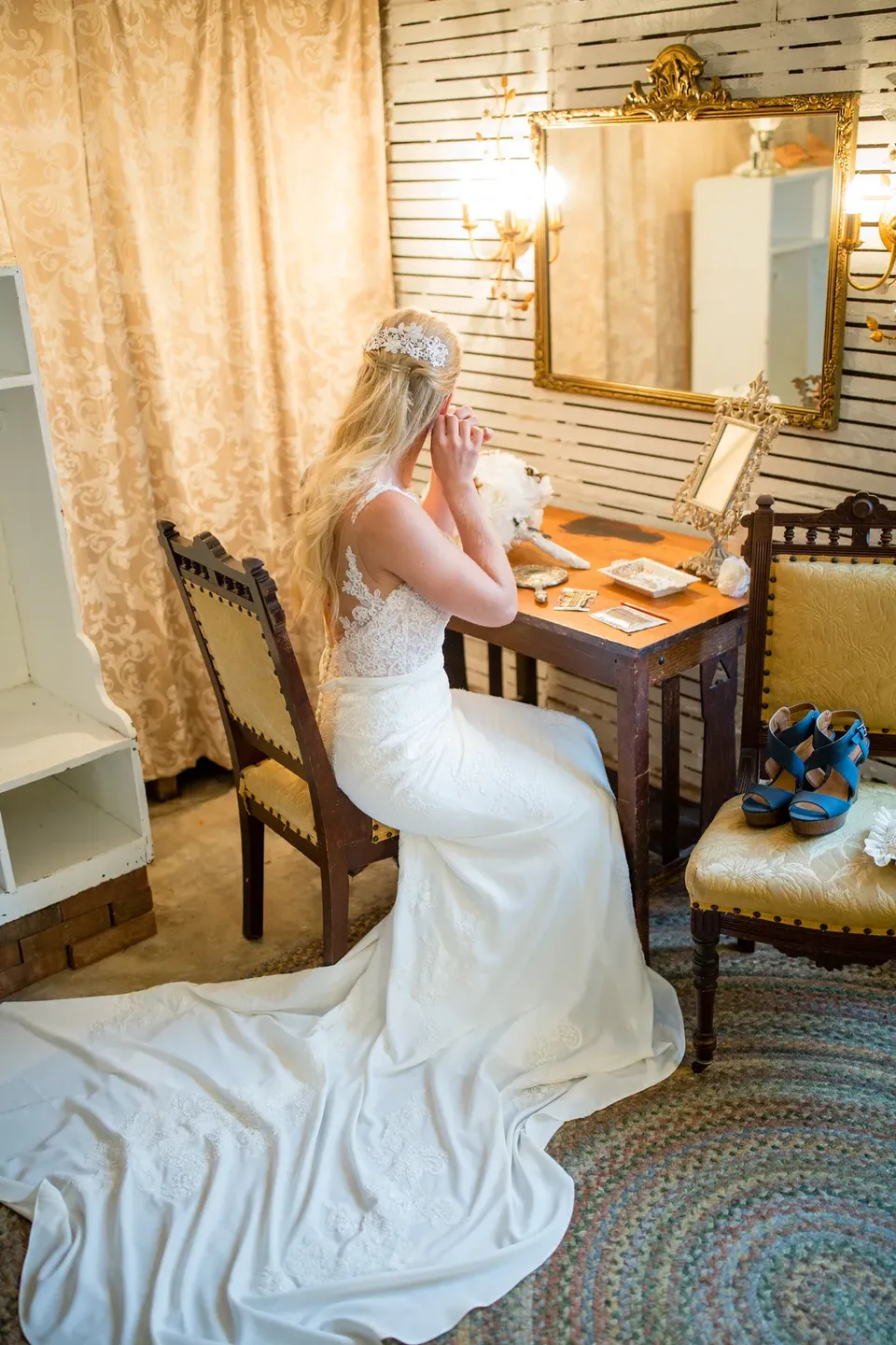 A bride seated at an antique vanity in the getting ready suite