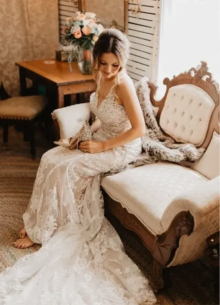 A bride seated on a tufted sofa in the bridal suite